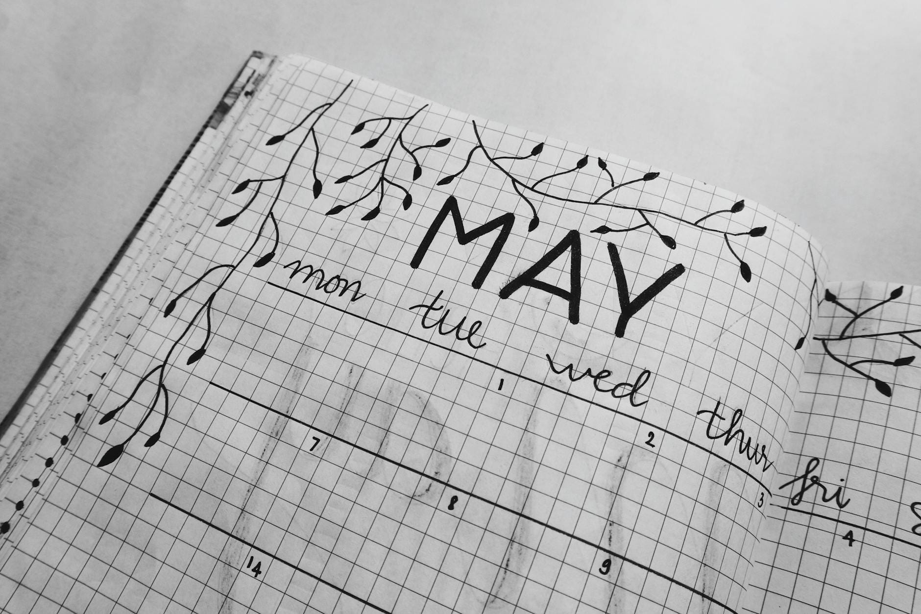 Czarno-biały planner bullet journal z ręcznie rysowanymi liśćmi na maj