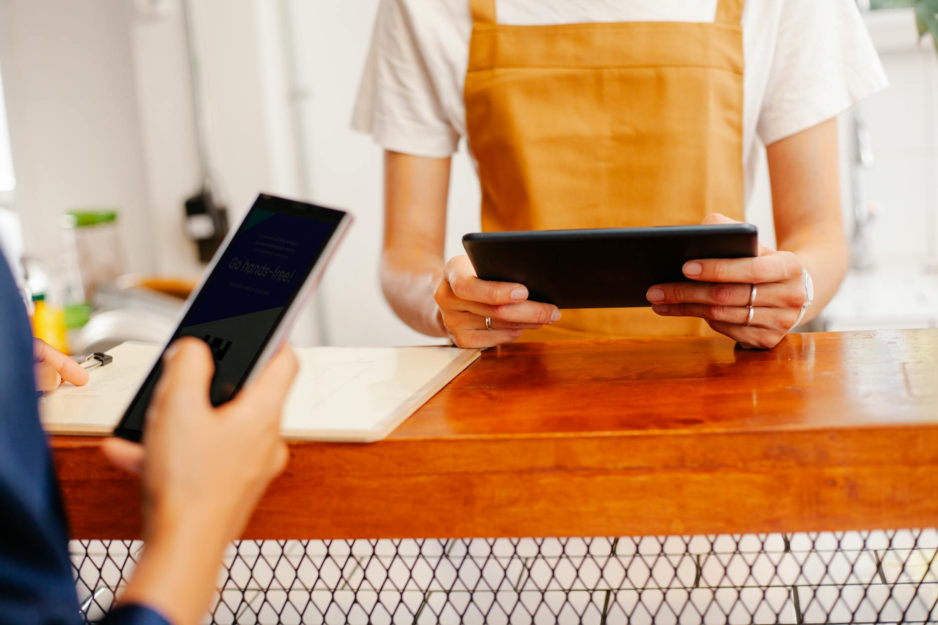 Dwie kobiety przeglądające internet na telefonie i tablecie w kawiarni
