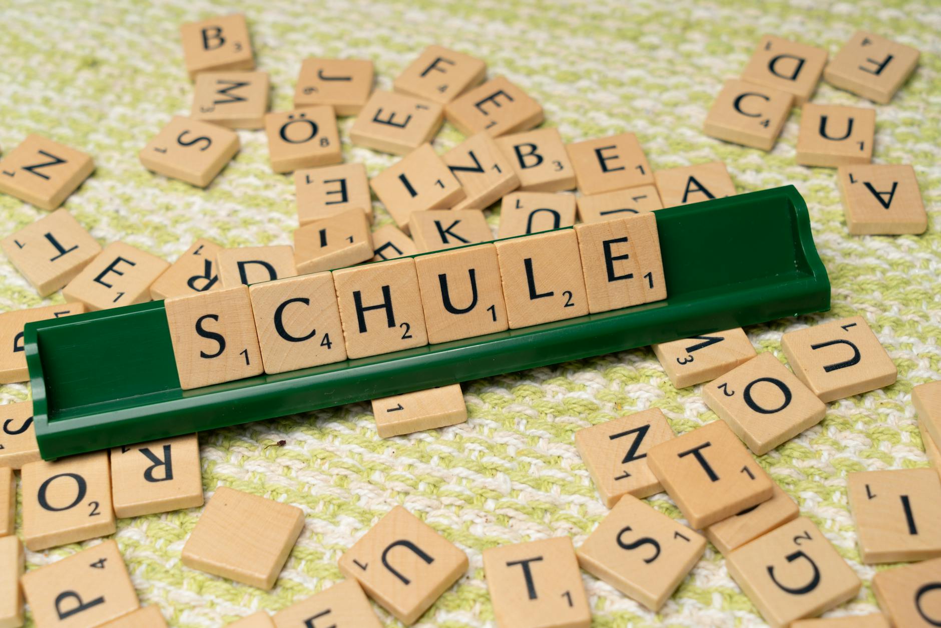 Kafelkowe literki układające się w niemieckie słowo Schule na stole