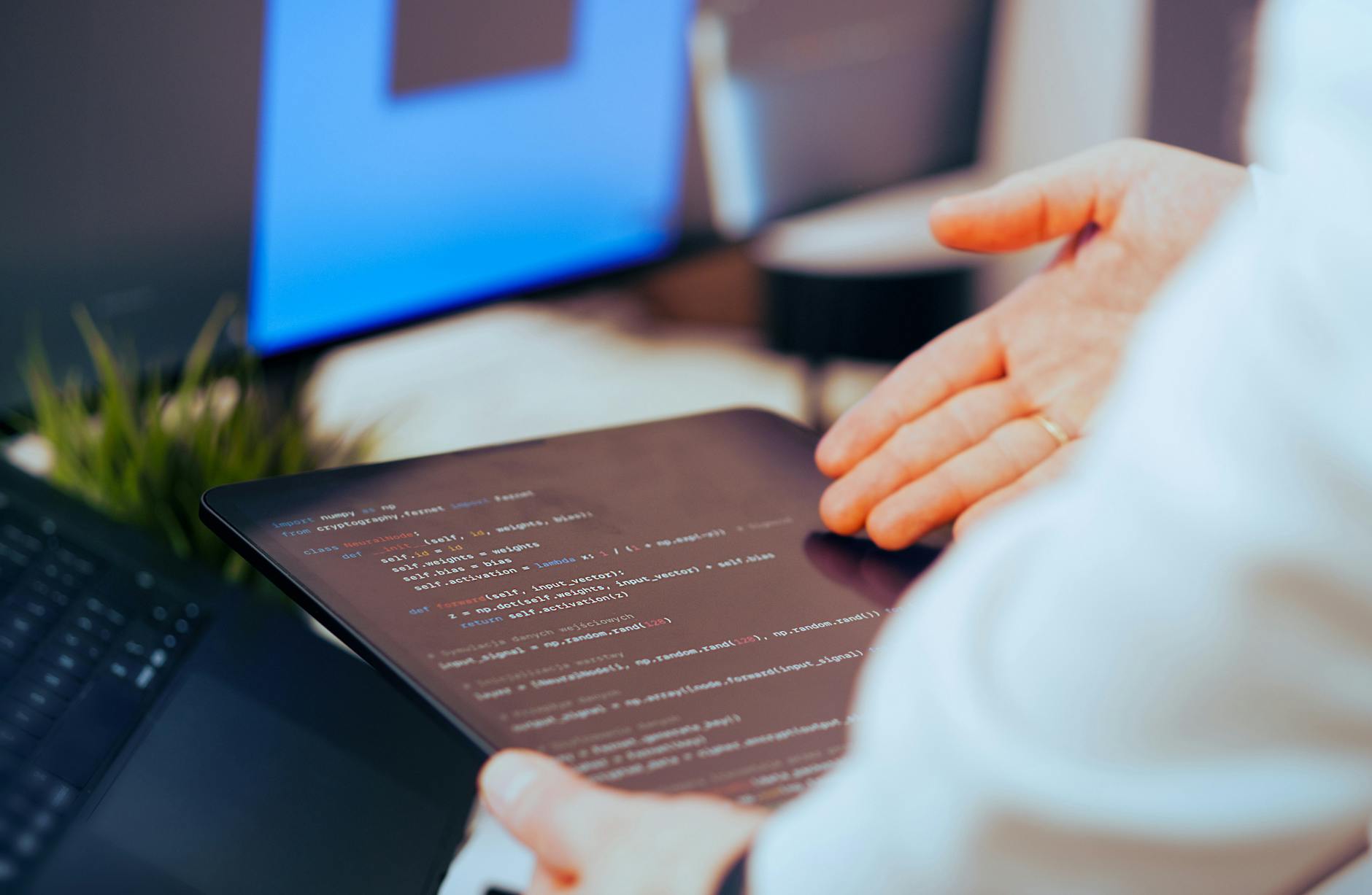 Programista przegląda kod na tablecie w nowoczesnym biurze